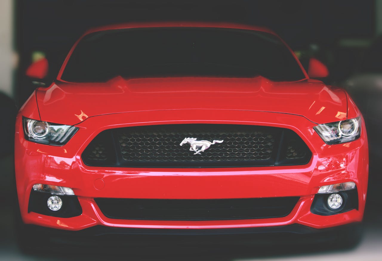 Bright red Ford Mustang showcased with a sleek front view in Ahmedabad.